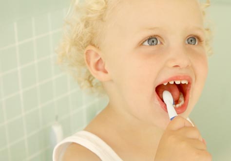 [Translate to greek:] kid cleaning teeth